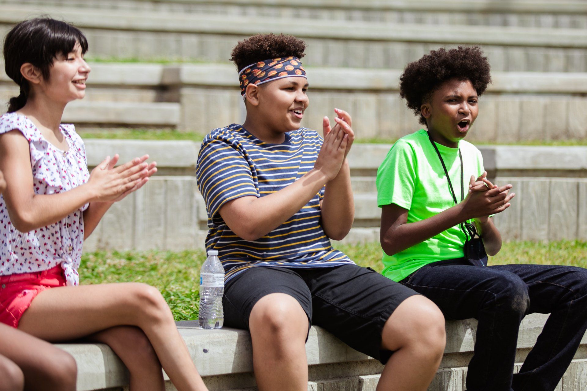 Young people cheering and clapping together outdoors